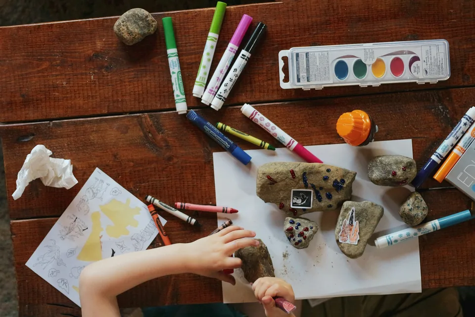 A child painting with art supplies at a table